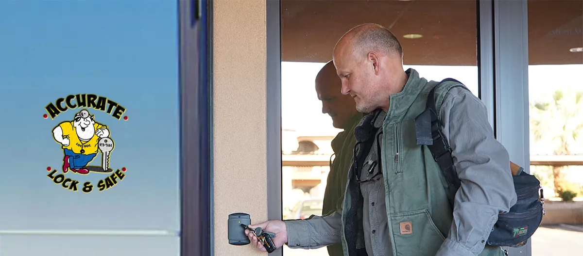 Man holding a key fob to a commercial card access reader at a St. George business entrance