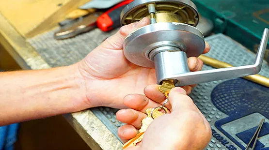 Locksmith rekeying a doorknob lock cylinder to work with a new key